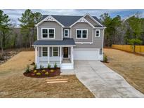 Charming two-story home with a welcoming front porch and attached two-car garage at 320 Duncan Creek Rd # 161, Lillington, NC 27546