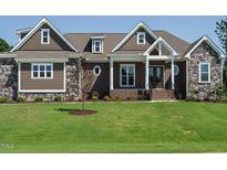 Charming home featuring stone accents, shingle siding, and a well-manicured lawn at 142 Batten Hill Ln, Selma, NC 27576
