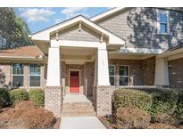 Brick home with a red door and covered porch at 15 Rolling Meadows Ln, Chapel Hill, NC 27517