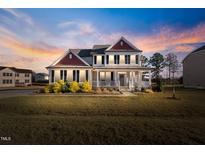 Charming two-story home featuring a welcoming front porch, and complemented by a beautifully landscaped yard at 46 Two Belles Ct, Angier, NC 27501