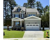 Charming two-story home with gray siding, black shutters, well-manicured lawn, and a two car garage at 2625 Silver Gate Ct, Wake Forest, NC 27587