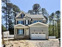 Charming two-story home featuring a two-car garage, inviting porch, and a mix of vertical and shake siding at 2625 Silver Gate Ct, Wake Forest, NC 27587