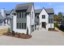 Stunning two-story home with a brick facade, a manicured lawn, and a paved driveway at 3410 Bradley Pl, Raleigh, NC 27607