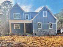 New two-story home features stone accents, siding, and a covered front porch at 123 Wichita Way, Louisburg, NC 27549