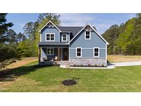 Charming two-story home with blue siding, stone accents and manicured lawn and craftsman details at 123 Wichita Way, Louisburg, NC 27549