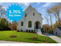 Inviting white brick home with manicured lawn and elegant arched windows offers classic style at 1409 Sedgefield St, Durham, NC 27705