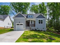 Charming craftsman home with gray siding, stone accents, and a well-manicured front yard at 235 Sequoia Dr, Louisburg, NC 27549