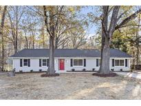 Charming single story home featuring a bright red front door and white painted brick at 3807 Hulon Dr, Durham, NC 27705