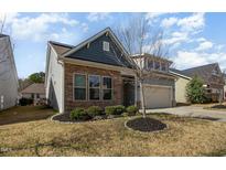Charming home featuring stone accents, a two-car garage, and well-manicured landscaping at 7533 Poplar Meadow Ln, Raleigh, NC 27616