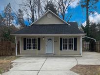 Beige house with gray roof, covered parking, and a fenced yard at 806 Piper St, Durham, NC 27704