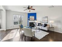 Bright living room featuring a fireplace, ceiling fan, hardwood floors, and stylish decor at 8204 Yaxley Hall Dr, Raleigh, NC 27616