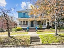 Charming two-story blue home featuring a welcoming front porch and beautiful landscaping at 417 Elm St, Raleigh, NC 27604