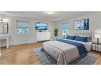 Bright bedroom features light hardwood floors, large windows, and a soothing blue color palette at 503 Marshall Way, Durham, NC 27705
