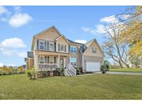 Charming two-story home with a covered porch and a well-manicured lawn at 835 Ruth Cir, Fuquay Varina, NC 27526