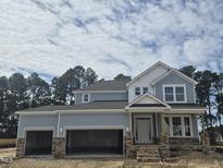 New construction two-story home with stone accents and three-car garage at 155 Shelby Meadow Ln, Angier, NC 27501