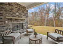Cozy outdoor patio with stone fireplace and seating, perfect for relaxing and enjoying the view at 2021 Abbeyhill Dr # 66, Raleigh, NC 27610