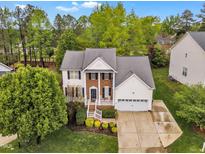 Traditional two-story home boasts a manicured lawn, attached two-car garage and a charming front porch at 3236 Forest Mill Cir, Raleigh, NC 27616