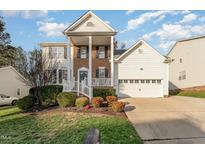 Two story home with brick and siding facade, front porch, attached two car garage, landscaping and driveway at 3236 Forest Mill Cir, Raleigh, NC 27616