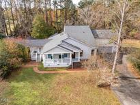 Charming home with a welcoming front porch and beautiful surrounding landscape, perfect for enjoying nature at 135 Weatherbend, Pittsboro, NC 27312