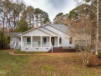 Charming single-story home featuring a covered front porch, gray siding, and well-maintained landscaping at 135 Weatherbend, Pittsboro, NC 27312