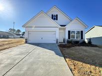 White house with gray stone accents, a two-car garage, and a concrete driveway at 174 Vega Loop, Sanford, NC 27330