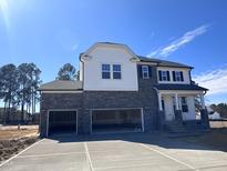 Stunning two-story home featuring a stone facade and a spacious three-car garage at 199 Shelby Meadow Ln, Angier, NC 27501