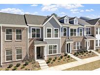 Attractive townhome featuring brick and gray siding, complemented by manicured landscaping and a welcoming entrance at 281 Chesapeake Commons St # 95, Garner, NC 27529
