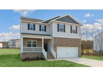 Two-story house with brick and vinyl siding, a two-car garage, and a front porch at 70 Scenic Rock Dr, Youngsville, NC 27596