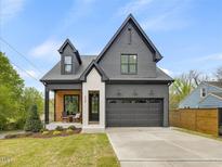 Beautiful two-story home with a gray brick exterior, a two-car garage, and a cozy front porch at 734 S State St, Raleigh, NC 27601