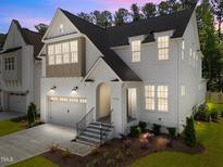 Stunning two-story home featuring a white brick facade, a two-car garage, and manicured landscaping at 1721 Burnette Garden Path, Raleigh, NC 27612