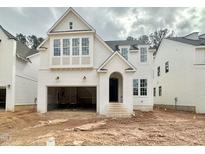 Stunning two-story home with white brick accents and a prominent arched entryway, creating a welcoming facade at 1721 Burnette Garden Path, Raleigh, NC 27612
