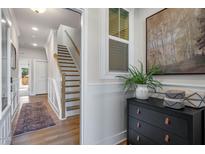 Inviting entryway with stairs, stylish decor, and wood floors create a warm welcome to this beautiful home at 211 Pond View Ct # 5, Fuquay Varina, NC 27526