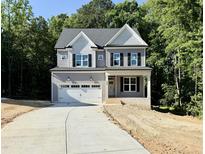 Two-story home featuring a two-car garage, a covered front porch, and a beautifully landscaped yard at 2624 Silver Gate Ct, Wake Forest, NC 27587