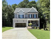 Two-story home features a gray facade, black shutters, and an attached, open garage, plus a front porch at 2624 Silver Gate Ct, Wake Forest, NC 27587