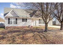 Charming single-story home with white siding, black shutters and mature trees in the front yard at 113 S Friars Chase Ln, Fuquay Varina, NC 27526