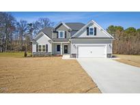 Charming two-story home with a two-car garage, covered entry, and light gray siding at 39 Winterwood Dr, Benson, NC 27504