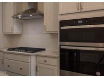 Modern kitchen features stainless steel appliances, light countertops, and a contemporary range hood at 482 Traditions Grande Blvd # 30, Wake Forest, NC 27587