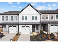 New two-story townhome with a two car garage, light gray and white paint, and manicured landscaping at 703 Jamescroft Way, Rolesville, NC 27587