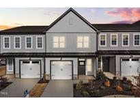 Charming townhouse showcasing a well-manicured lawn, a clean driveway, and an attached garage at 703 Jamescroft Way, Rolesville, NC 27587