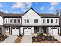 Newly built townhomes featuring modern designs, individual garages, and tastefully landscaped front yards at 707 Jamescroft Way, Rolesville, NC 27587