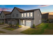 New two-story townhouse featuring a one car garage, gray siding, and manicured landscaping at 709 Jamescroft Way, Rolesville, NC 27587