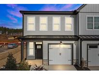 Charming two-story townhome with grey siding, white trim, and a one-car garage offers modern curb appeal at 709 Jamescroft Way, Rolesville, NC 27587