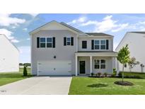 Charming two-story home features a clean gray facade, attached garage, and manicured lawn at 98 Ethel Ln, Angier, NC 27501