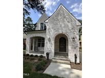 Charming whitewashed brick home featuring an arched entryway and professionally landscaped front yard at 3302.5 Hall Pl, Raleigh, NC 27607