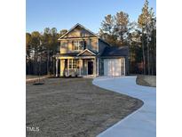 Two-story house with gray siding, white garage doors, and a curved driveway at 788 Roberts Rd, Sanford, NC 27332