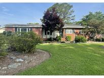 Charming brick home featuring a well-manicured lawn and mature landscaping at 229 Davis Mill Rd, Selma, NC 27576