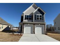 Beautiful two-story home featuring a 2-car garage, stone accents, and eye-catching blue shingle siding at 350 Tormore, Homesite 126, Sanford, NC 27330