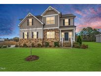 Beautiful two-story home with stone accents, a well-manicured lawn, and a welcoming front porch at 254 Dungannon, Clayton, NC 27520