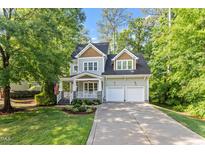 Charming two-story home featuring a welcoming front porch, two-car garage, and lush landscaping at 4324 Brighton Ridge Dr, Apex, NC 27539
