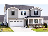 Charming two-story home featuring a two-car garage, stone accents, and a welcoming front porch at 59 Davinhall Dr, Fuquay Varina, NC 27526